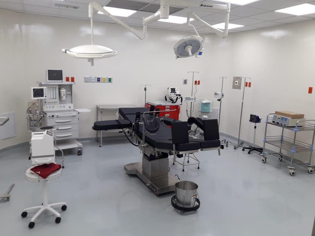 Quirófano equipado con mesa quirúrgica, lámparas cialíticas, máquina de anestesia y carro de paro.